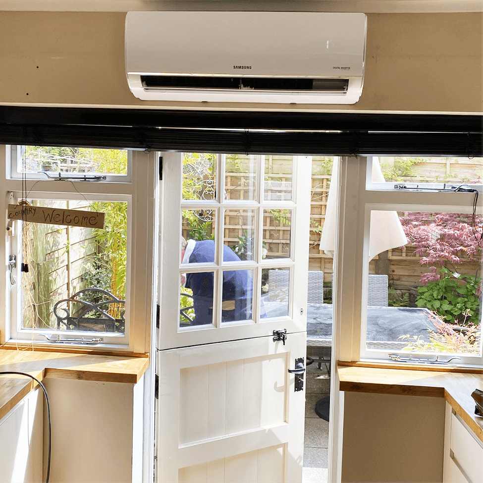 Wall-mounted air conditioning in a bright room overlooking a garden