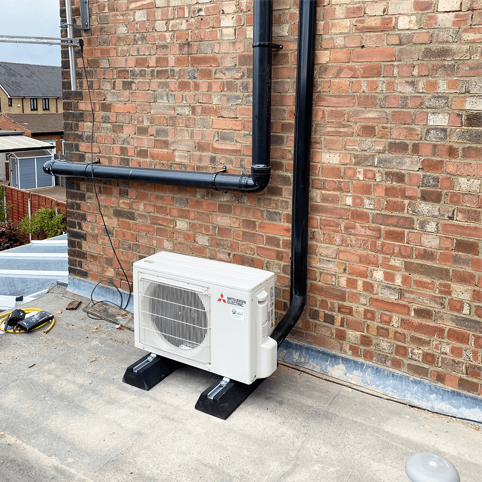 Outdoor condenser fitted beside a brick wall